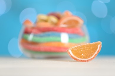 Photo of Sweet jelly slice on light table against blurred lights. Space for text
