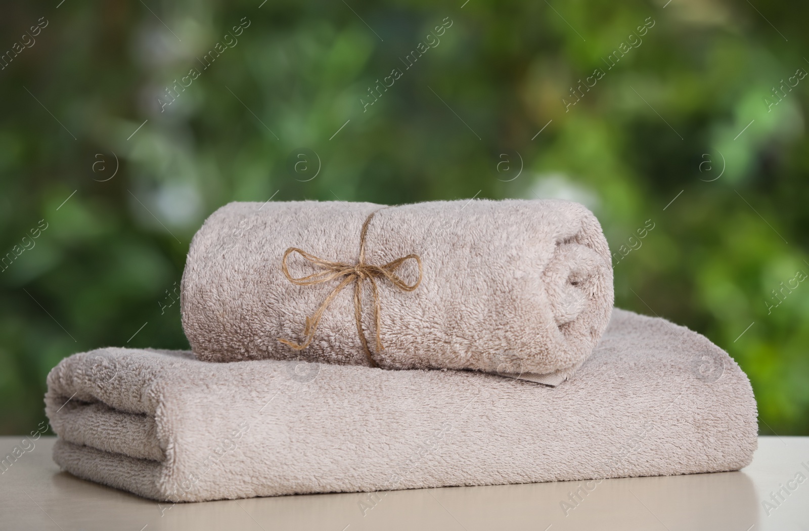 Photo of Beige soft towels on white table outdoors, closeup