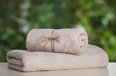 Photo of Beige soft towels on white table outdoors, closeup