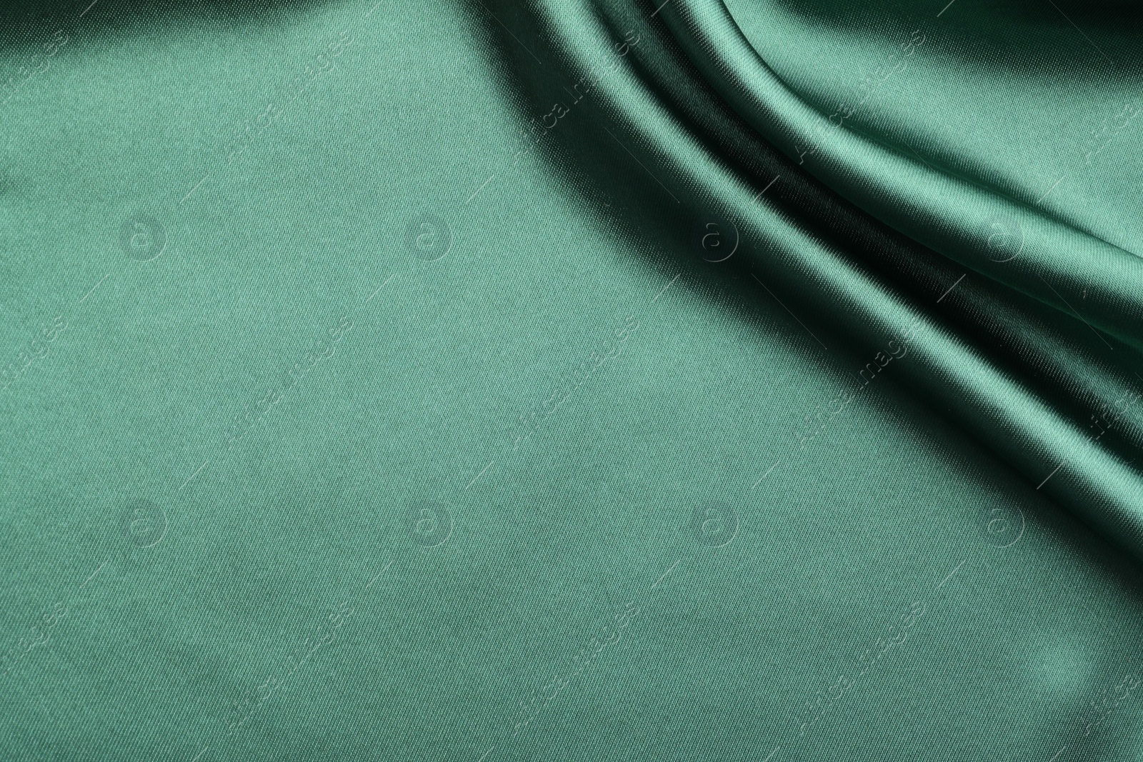 Photo of Crumpled green silk fabric as background, top view