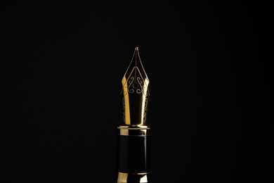 Photo of Beautiful fountain pen with ornate nib on black background, closeup