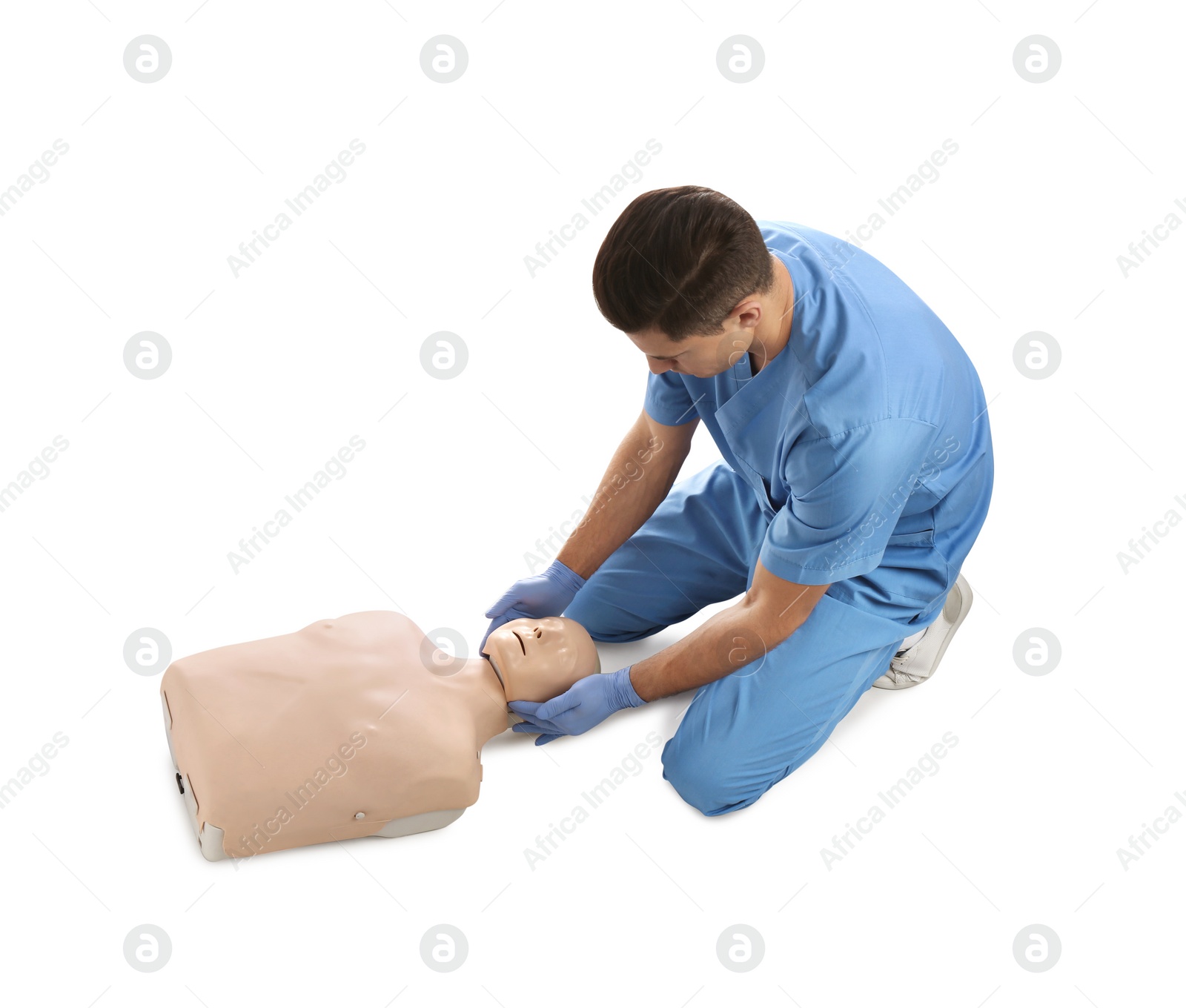 Photo of Doctor in uniform practicing first aid on mannequin against white background