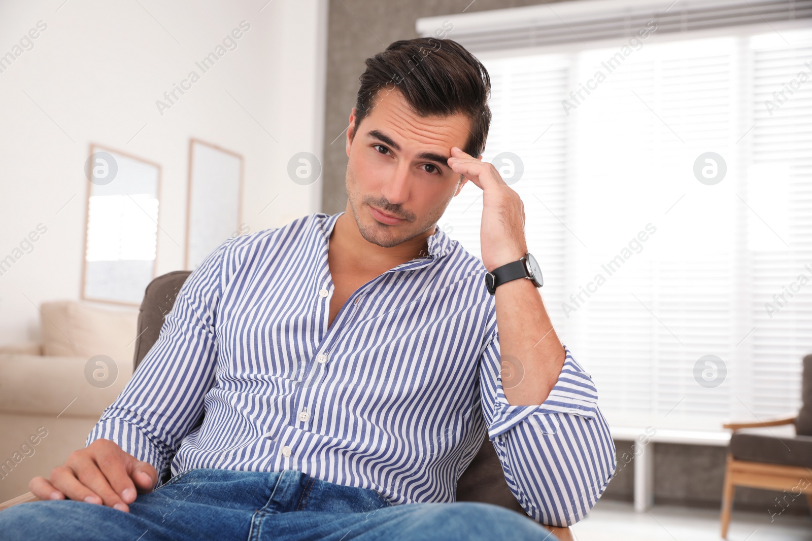 Photo of Portrait on handsome young man sitting in chair indoors