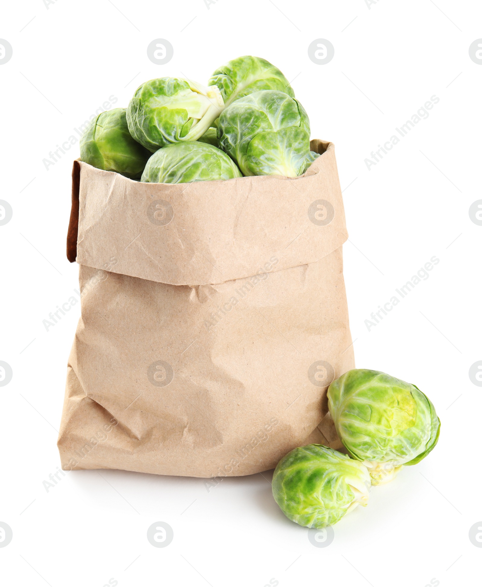 Photo of Fresh Brussels sprouts in paper bag on white background