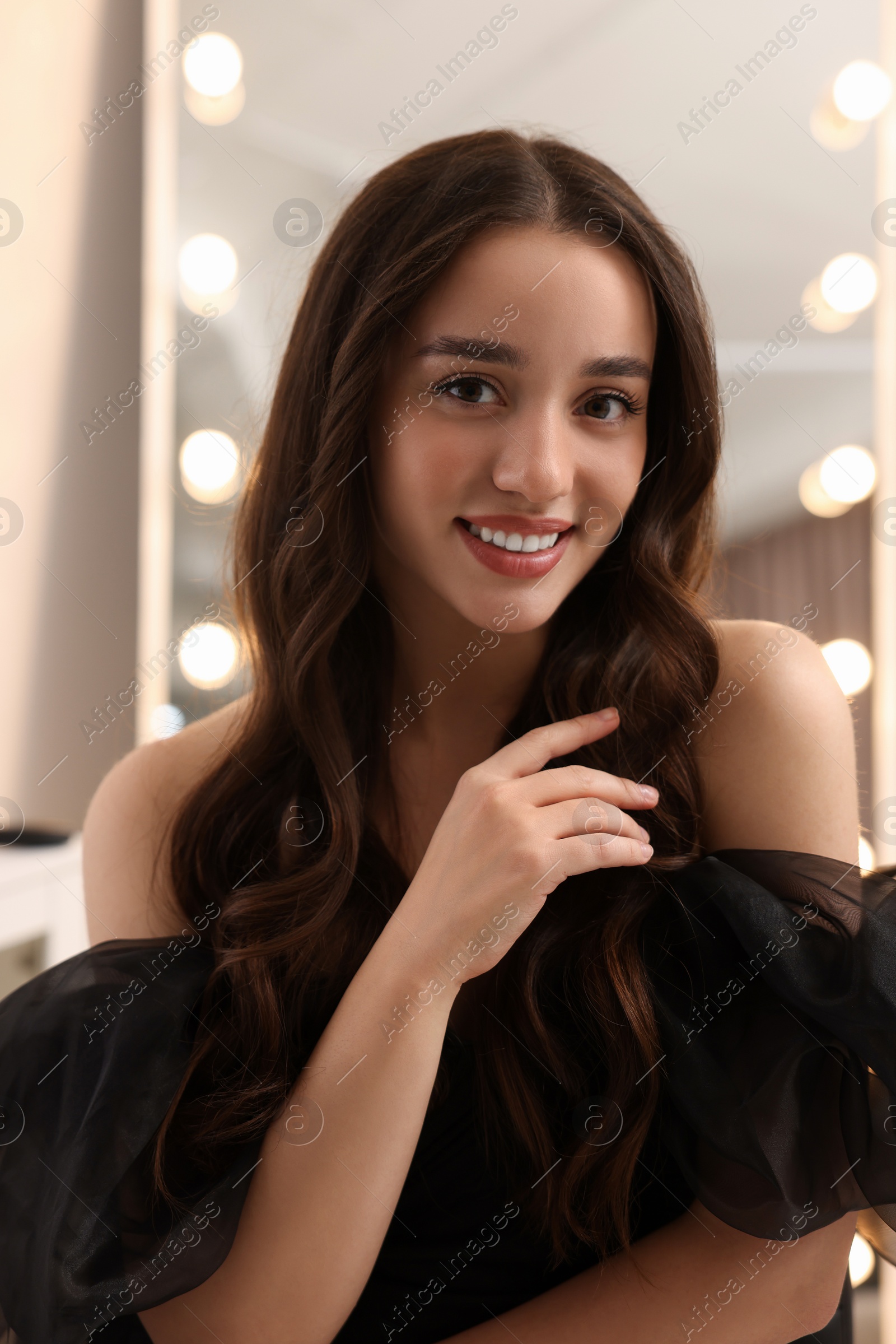 Photo of Portrait of smiling woman with curly hair indoors