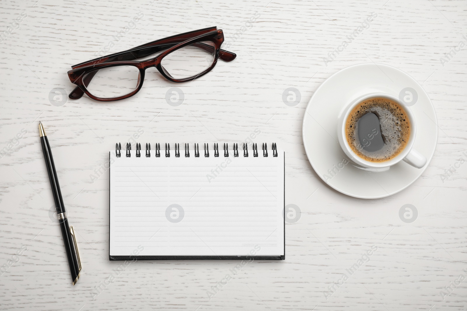 Photo of Flat lay composition with notebook and cup of aromatic coffee on wooden background