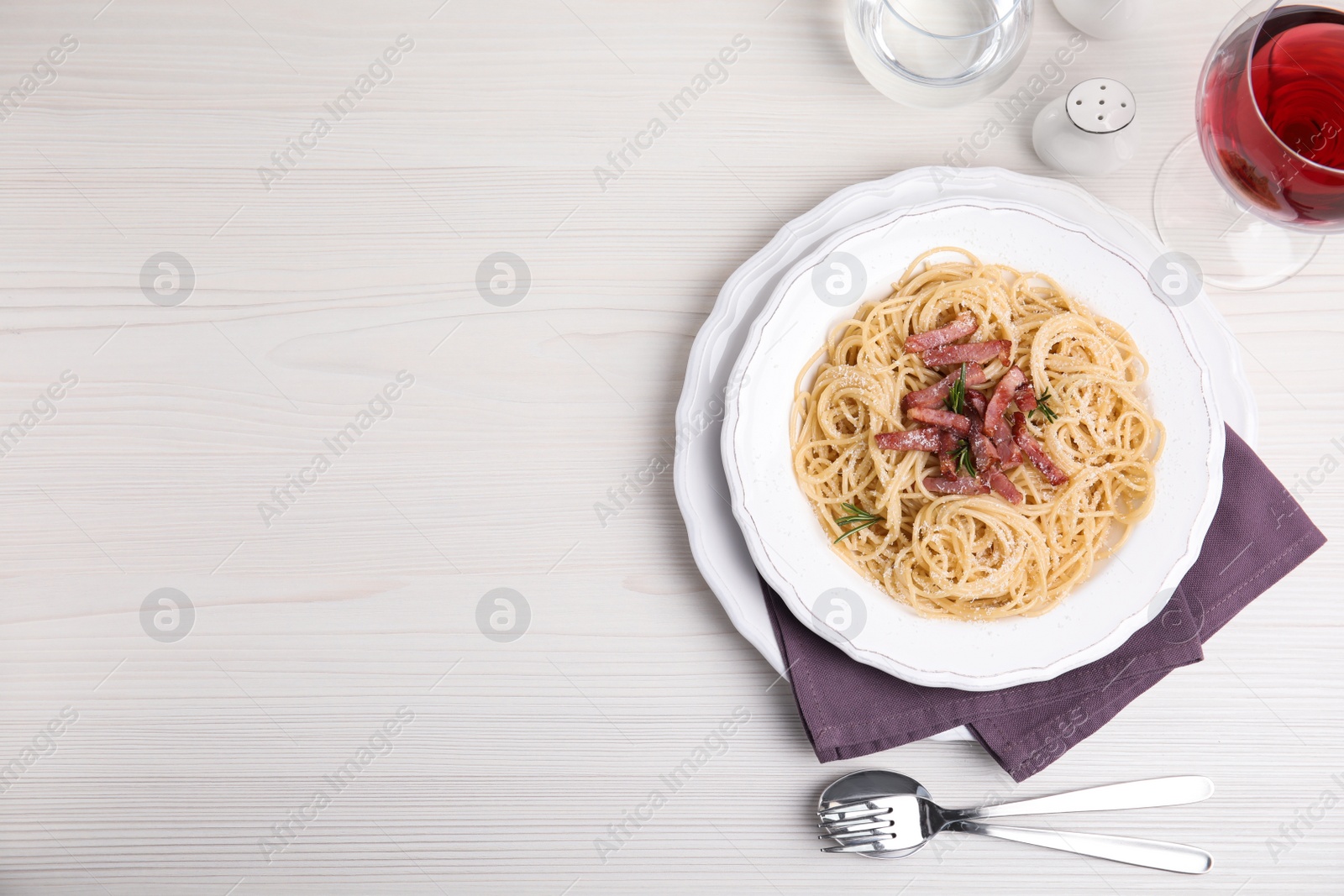 Photo of Delicious Carbonara pasta served on white wooden table, flat lay. Space for text