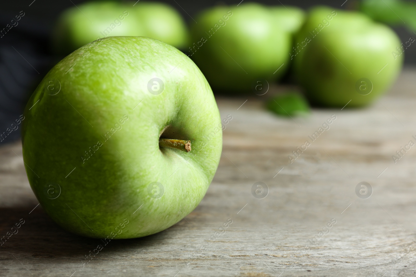 Photo of Fresh green apple on wooden table, closeup