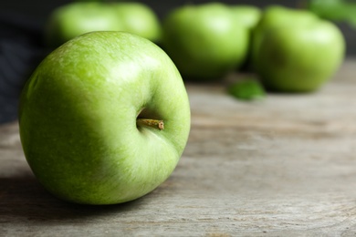 Fresh green apple on wooden table, closeup