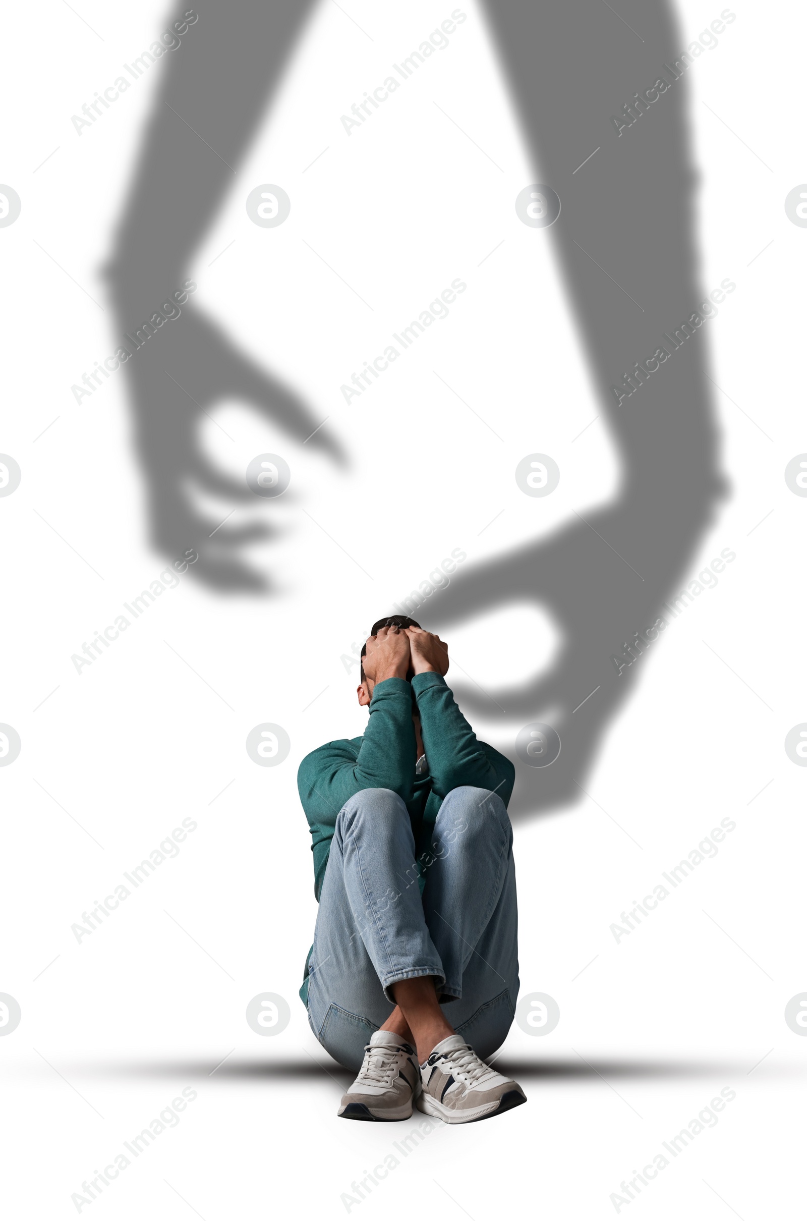 Image of Suffering from hallucinations. Scared man closing eyes because of shadow of monster hands reaching to him