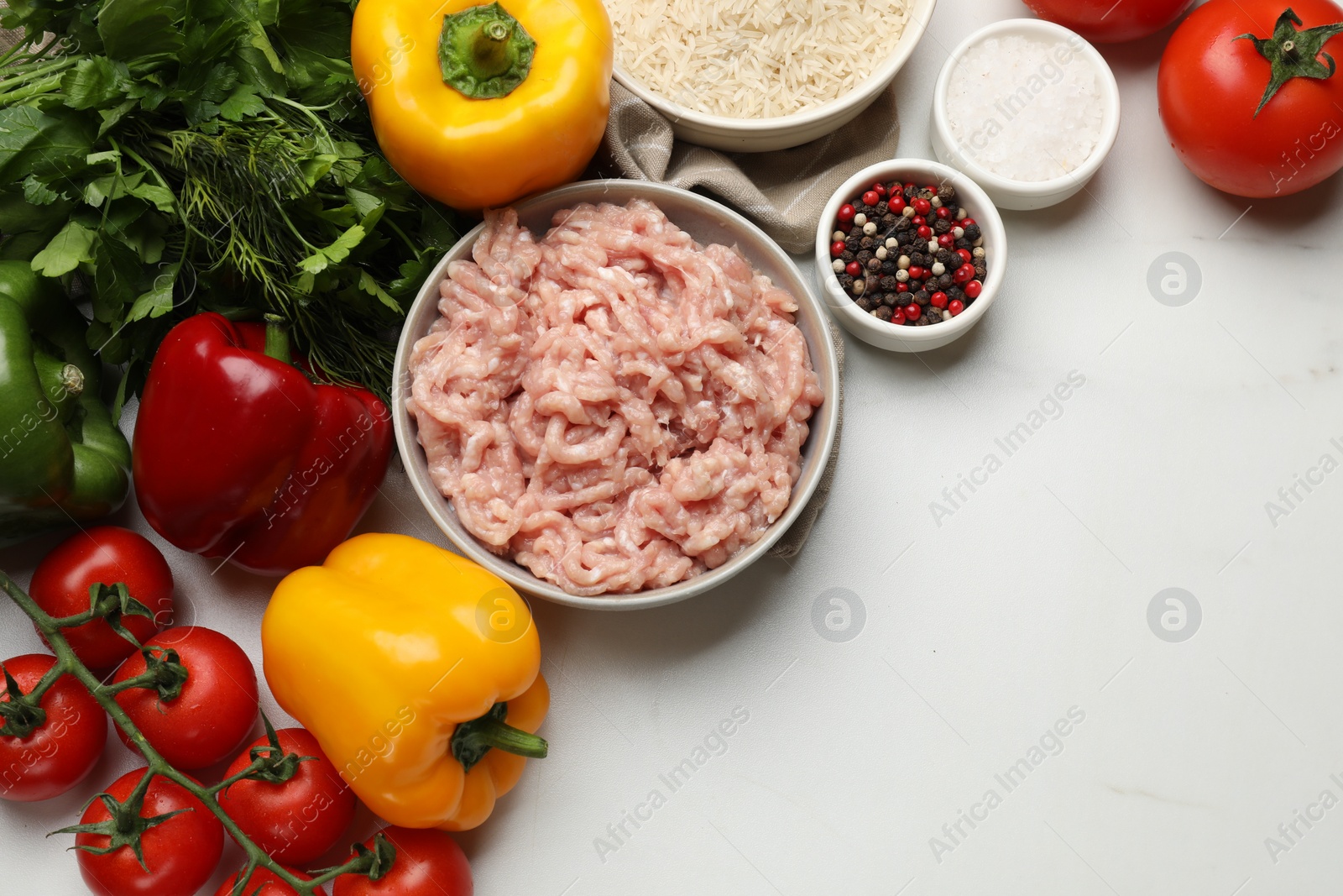 Photo of Making stuffed peppers. Ground meat and other ingredients on white marble table, flat lay. Space for text