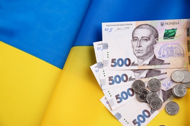 Ukrainian money on national flag, top view. Space for text