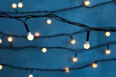 Photo of Beautiful Christmas lights on color background, closeup