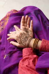 Woman with beautiful henna tattoos on hands, closeup. Traditional mehndi