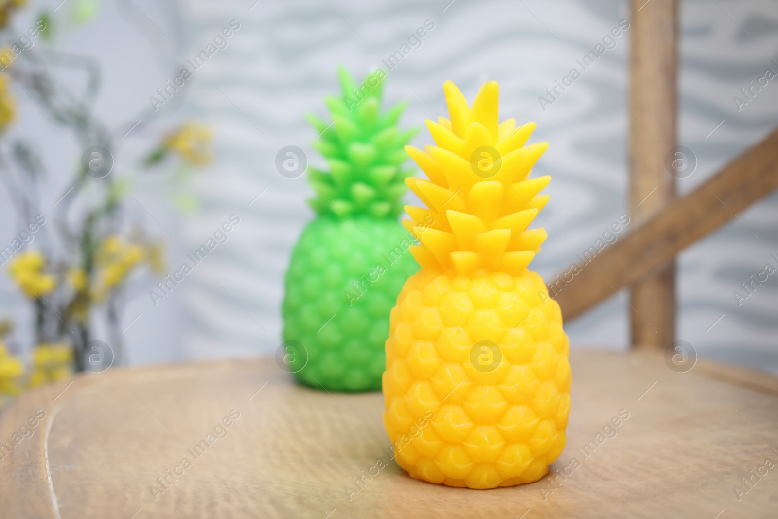 Photo of Pineapple shaped candles on table in room