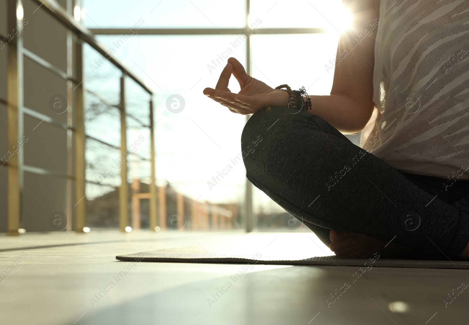 Photo of Young woman practicing yoga in sunlit room, closeup with space for text