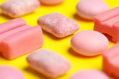 Pink bubble gums on yellow background, closeup