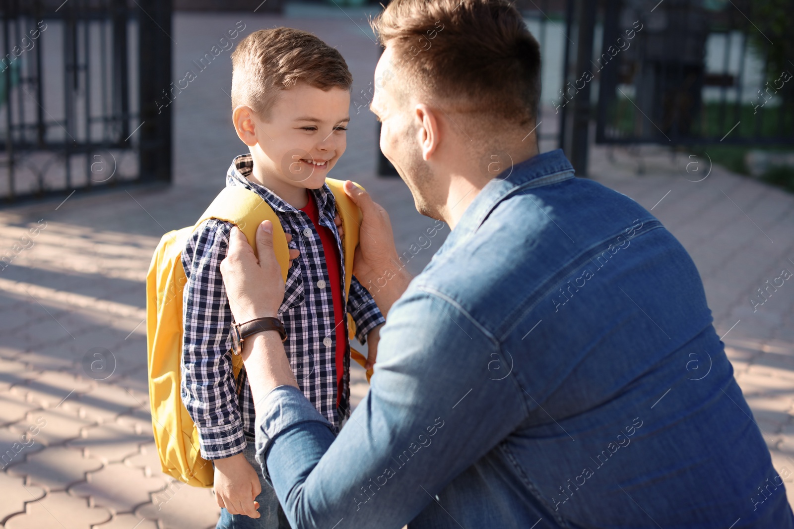 Photo of Young man saying goodbye to his little child near school