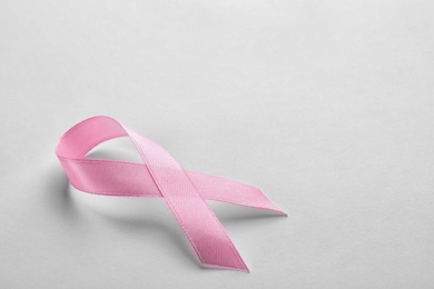 Pink ribbon on white background, space for text. Breast cancer awareness concept