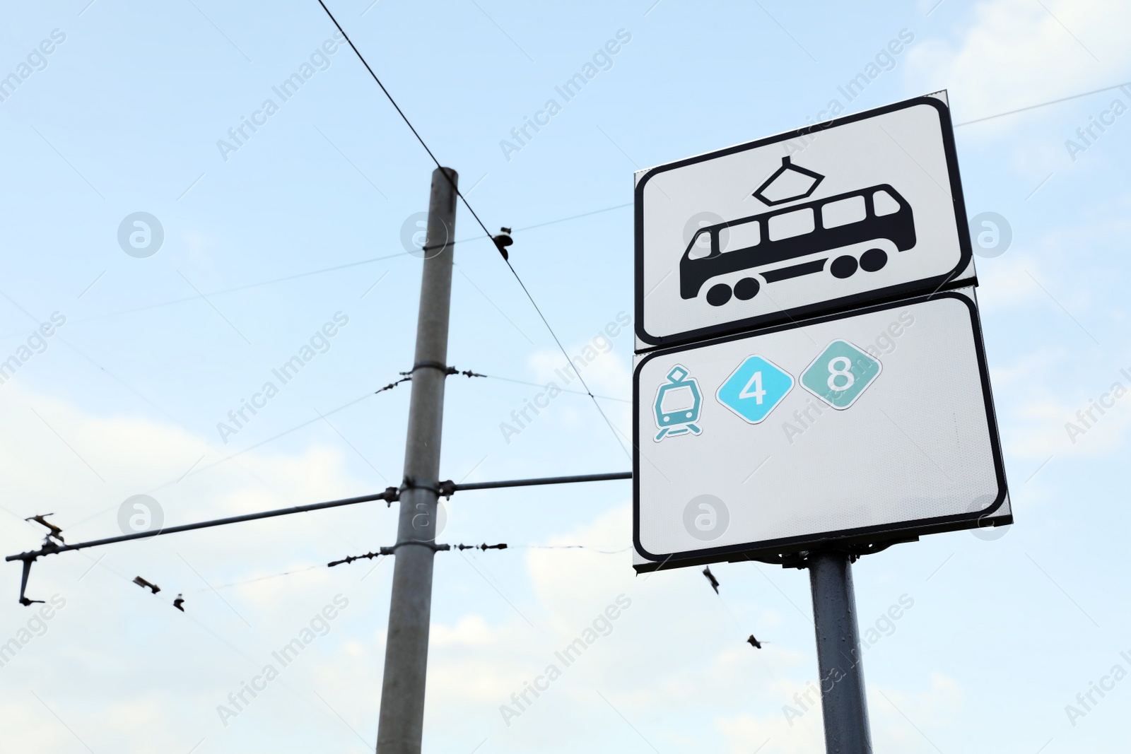 Photo of Tram stop sign against blue sky. Space for text