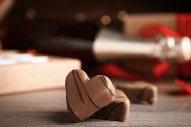 Photo of Tasty heart shaped chocolate candies on wooden table, closeup. Happy Valentine's day