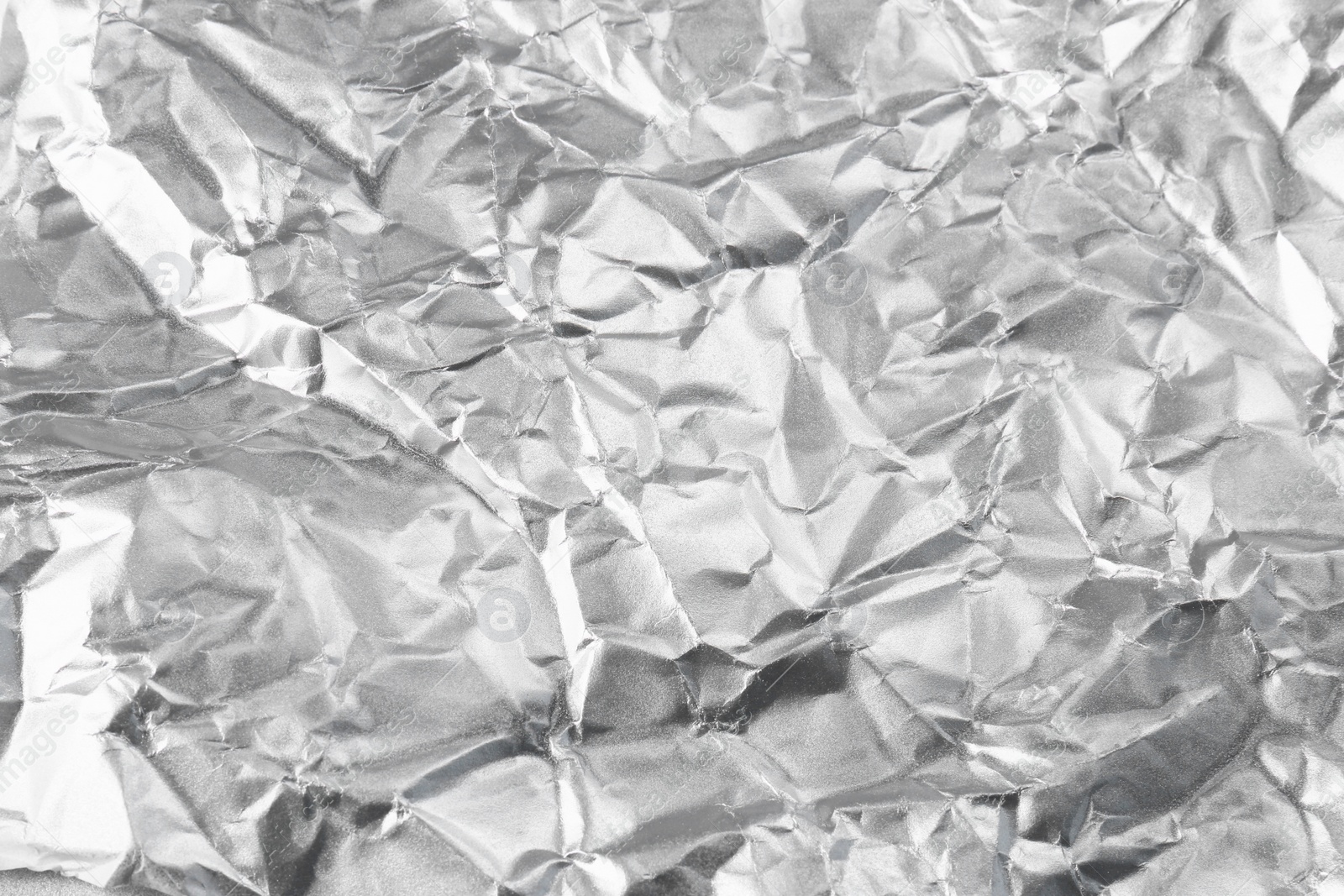 Photo of Crumpled silver foil as background, closeup view