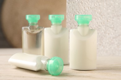 Photo of Mini bottles of cosmetic products on white wooden table