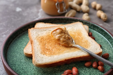 Plate with toasts and peanut butter on table