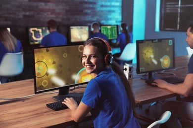 Photo of Woman playing video game in internet cafe