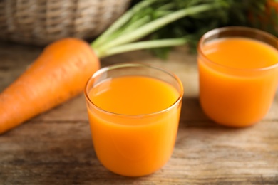 Freshly made carrot juice on wooden table