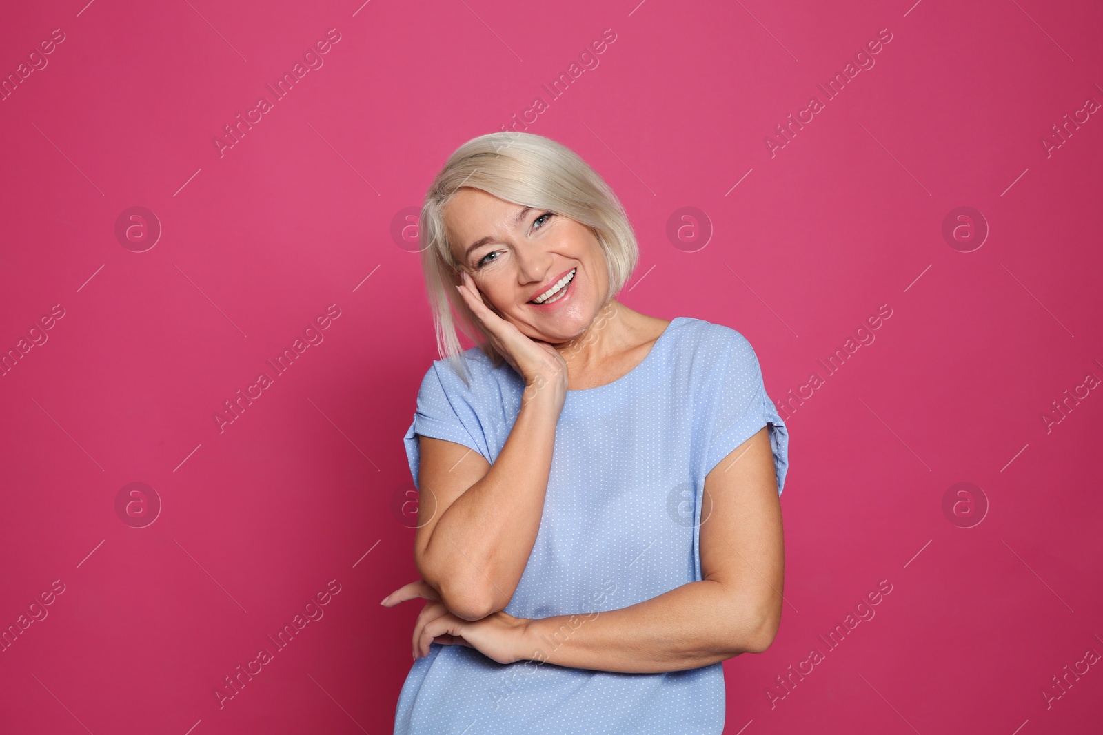 Photo of Portrait of mature woman laughing on color background