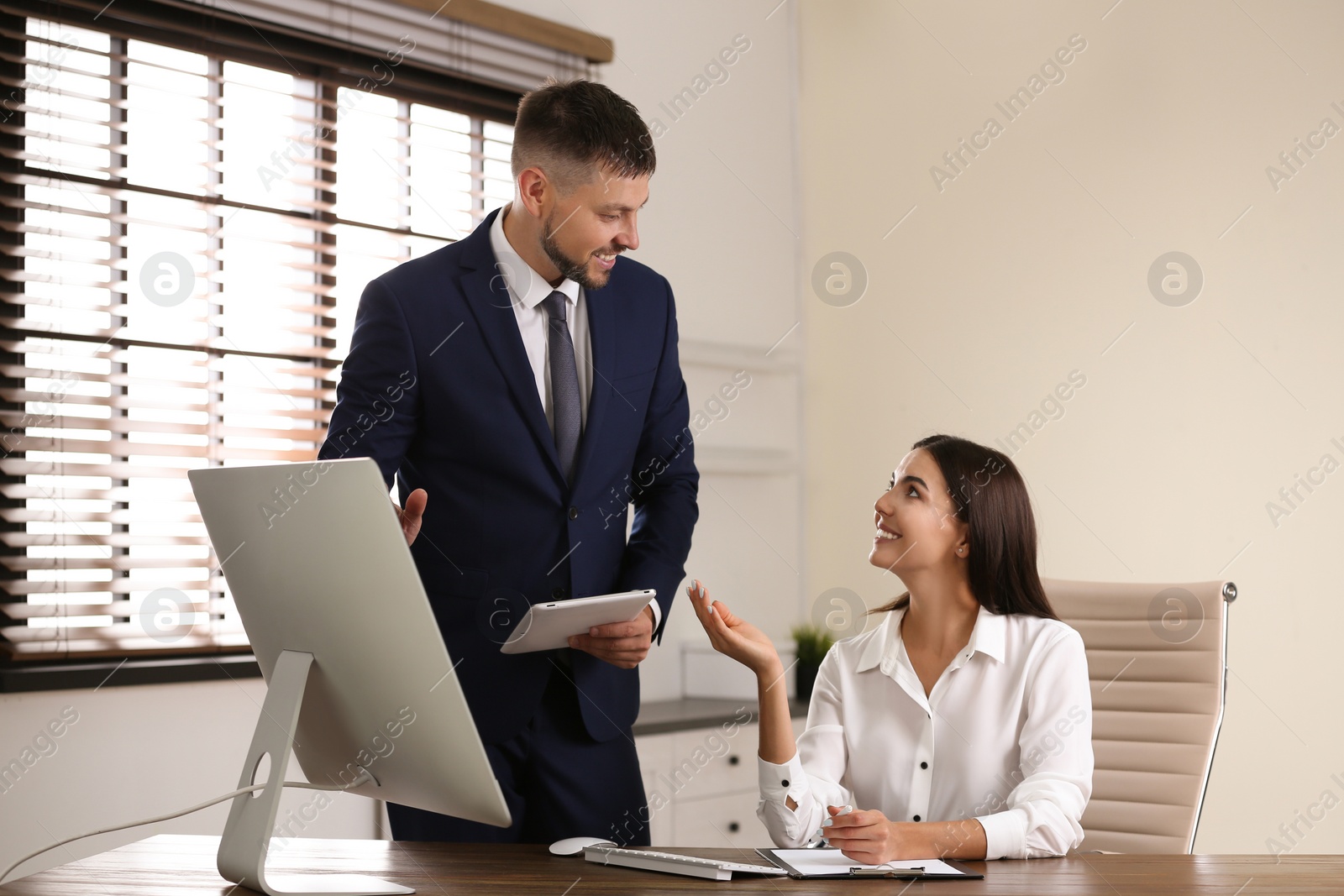 Photo of Man helping his colleague with work in office