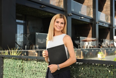 Female real estate agent with clipboard outdoors