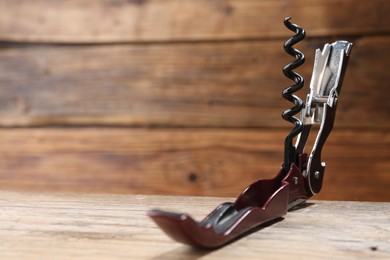 One corkscrew (sommelier knife) on wooden table, closeup. Space for text