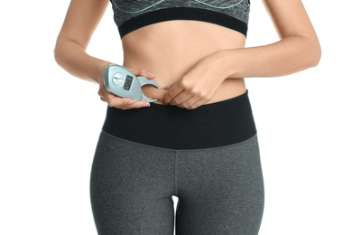 Photo of Young woman measuring body fat with caliper on white background, closeup