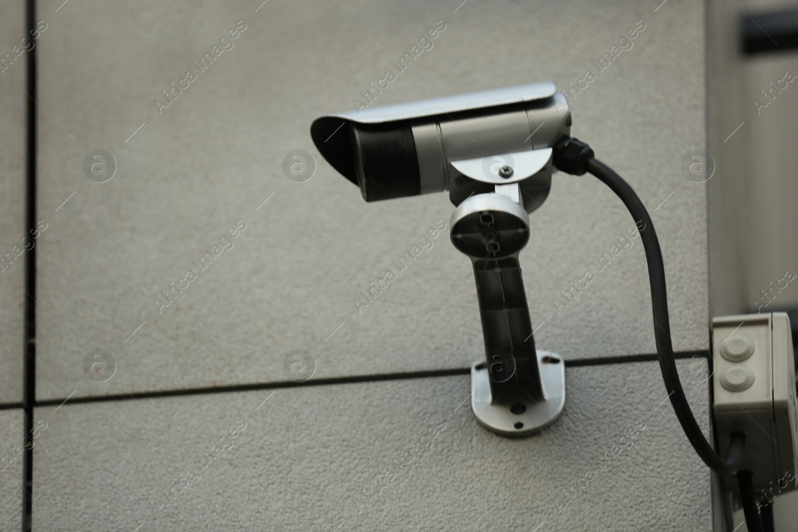 Photo of Modern CCTV security camera on building wall outdoors