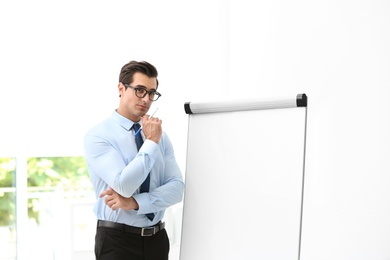 Photo of Professional business trainer near flip chart in office