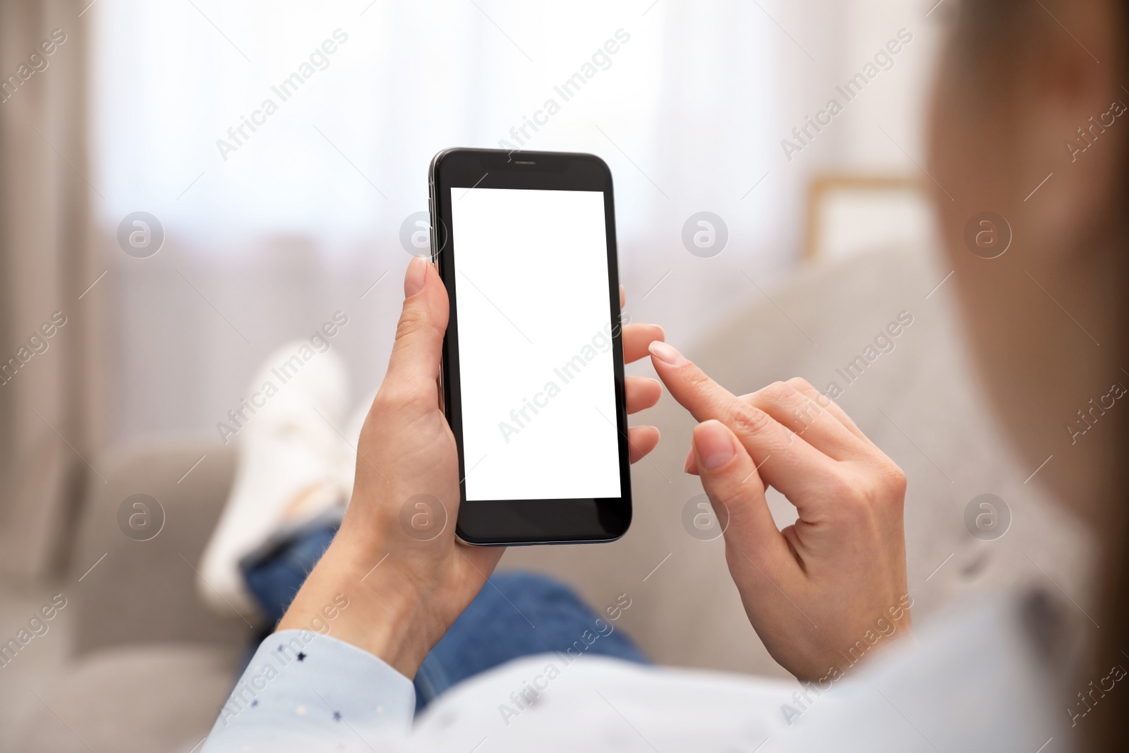 Photo of Woman holding smartphone with blank screen indoors, closeup of hands. Space for text