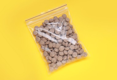 Photo of Beer yeast pills on yellow background, top view