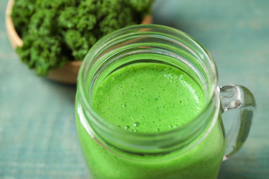 Photo of Tasty fresh kale smoothie on light blue table, closeup