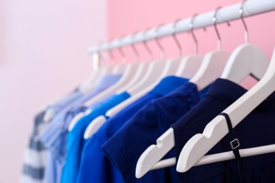 Photo of Bright clothes hanging on rack in room