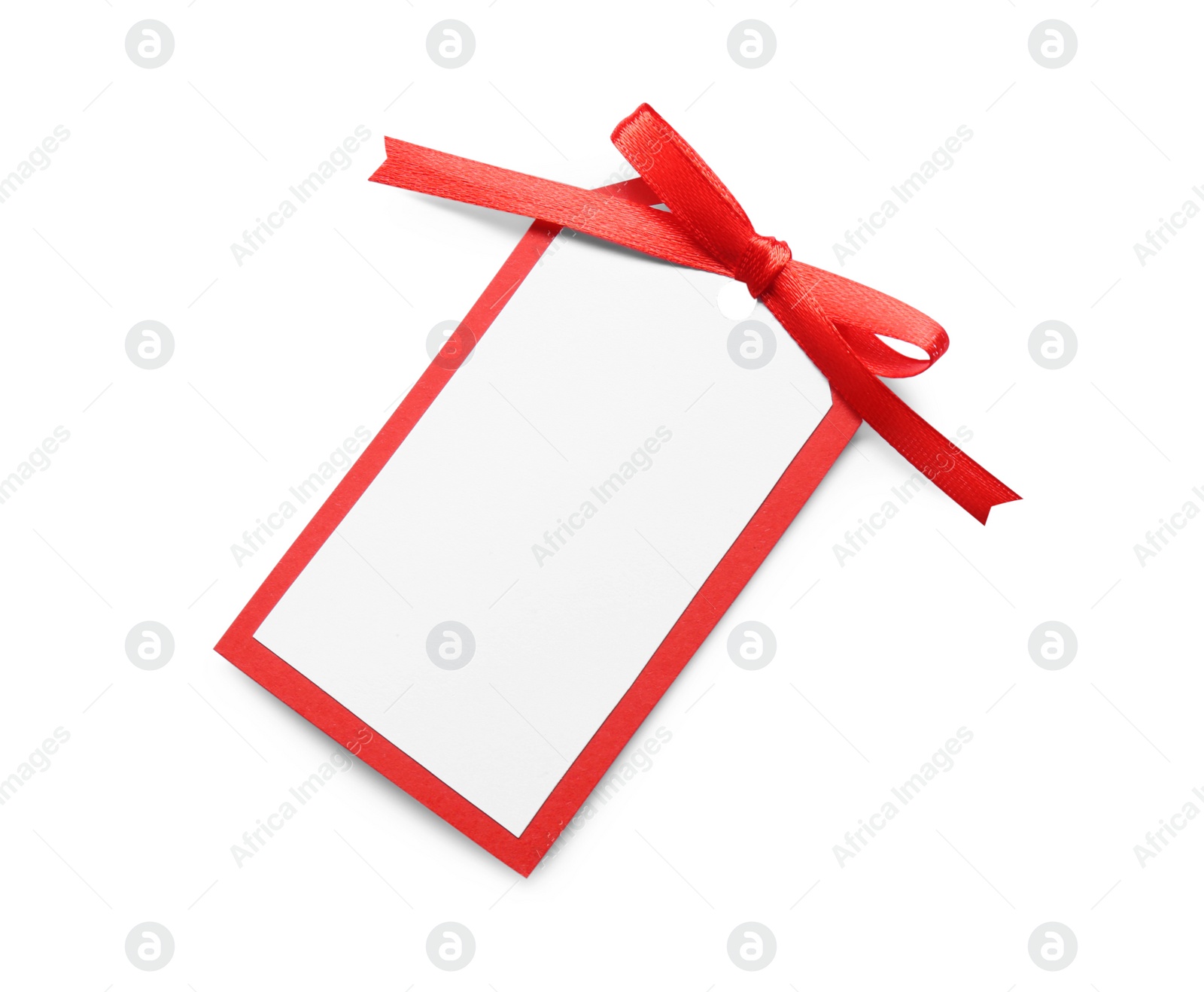 Photo of Blank gift tag with red satin ribbon on white background, top view