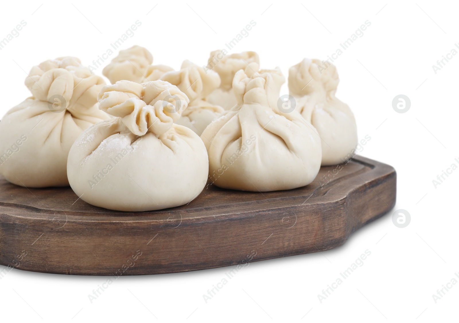 Photo of Wooden board with uncooked khinkali (dumplings) isolated on white. Georgian cuisine