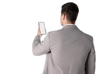 Photo of Man holding smartphone with blank screen on white background, back view