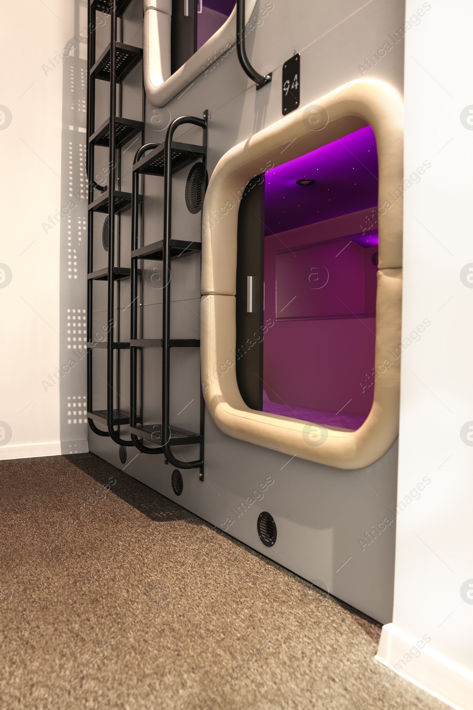 Photo of Capsule with purple light in modern pod hostel