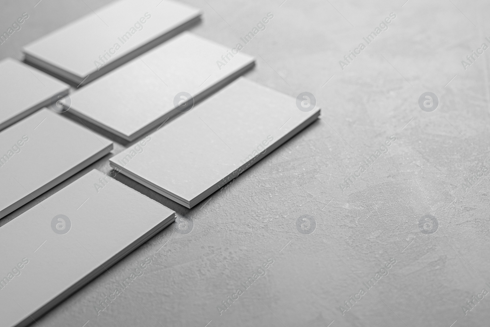 Photo of Blank business cards on light grey textured table, closeup. Mockup for design