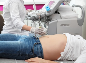 Doctor conducting ultrasound examination of internal organs in clinic, closeup