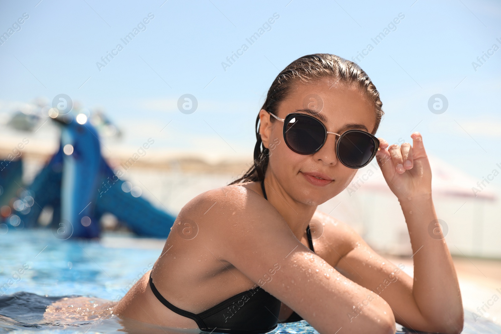 Photo of Young woman in outdoor swimming pool. Summer vacation