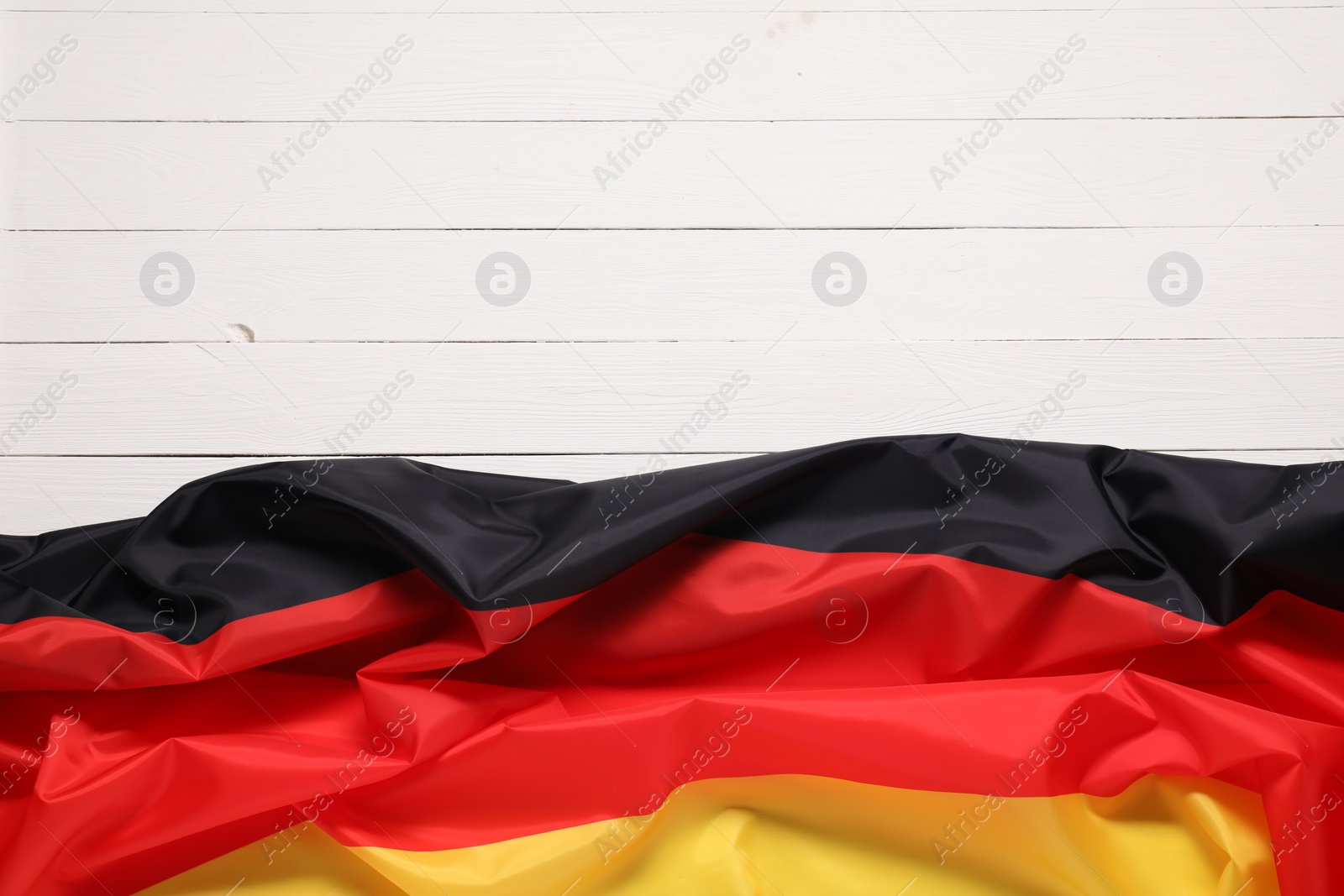 Photo of Flag of Germany on white wooden background, top view. Space for text