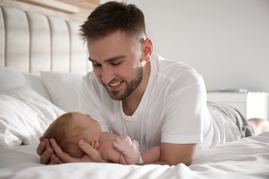 Photo of Father with his newborn son at home